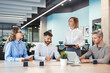 © ty - Team of business people having discussion at table in creative office.