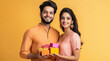 © Neha - young indian couple holding gift box on diwali festival