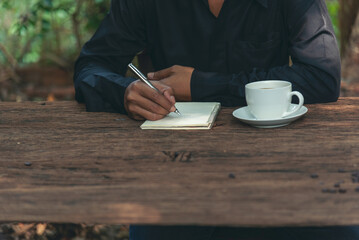 Close up hands of man sitting office desk holding sweet coffee cup relax and enjoy with happy time. Hot coffee mug in hand. Man holding coffee cup relaxing after work at office warm taste in cafe