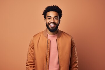 Canvas Print - Portrait of a satisfied afro-american man in his 20s wearing a trendy bomber jacket over light wood minimalistic setup