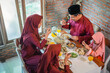 © Odua Images - four Muslim family members eating together at the dining table at home