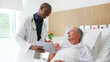 © Monkey Business - Doctor Looking At Digital Tablet With Senior Male Patient In Hospital Bed In Geriatric Unit