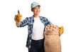 © Ljupco Smokovski - Young female farmer holding potatoes in a sack and gesturing thumbs up