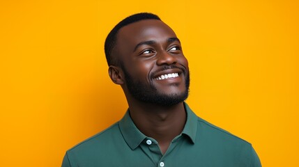 Poster - Portrait of a smiling young man looking up against a yellow background.