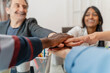 © Lomb - Diverse team unity, multiethnic colleagues joining hands, workplace inclusion and collaboration