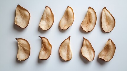 Wall Mural - Crispy, dried pear slices arranged on a clean white surface.