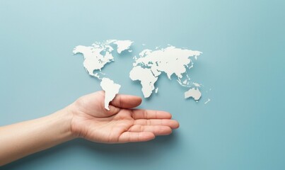 Hand holding paper cutout of world map on blue background. Concept of global connections and international reach.