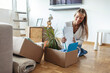 © Jelena Stanojkovic - New home, real estate and woman packaging box for property sale, mortgage and house investment. Moving, packing and person with cardboard for relocation, unboxing or storage for delivery to apartment.