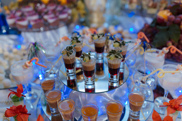 A table with many different types of drinks and food, including a variety of cocktails and appetizers