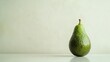 © Elshad Karimov - An avocado, a pear-shaped fruit with smooth, green skin, rests alone against a stark white backdrop. Its skin is unblemished, hinting at the creamy, buttery flesh within