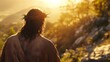 © Luka - Jesus Christ with a crown of thorns on his head, seen from behind, looking at the sun in a mountainous landscape