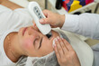 © RomanR - beautician doing  cosmetic procedure with ultrasound skin tightening for rejuvenation woman face