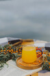 © nutka_13 - Sea buckthorn tea in a transparent cup on a wooden tray.