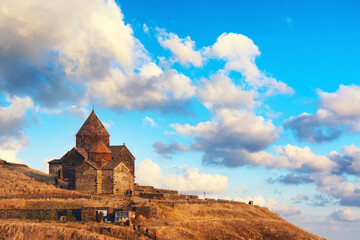 Ancient Sevanavank monastery on Lake Sevan in Armenia against blue colorful sky with clouds