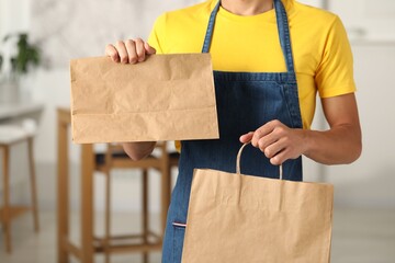 Sticker - Fast-food worker with paper bags indoors, closeup