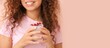 © Pixel-Shot - Young woman with tasty yogurt on pink background with space for text