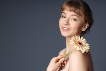 Canvas Print - Beautiful young woman with flower on dark background, closeup