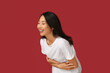 © Pixel-Shot - Young Asian woman laughing on red background