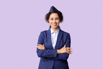 Wall Mural - Beautiful African-American stewardess on lilac background