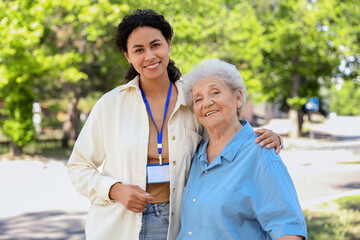 Canvas Print - Young African-American female medical worker with elderly woman outdoors