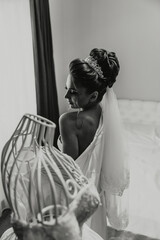 Poster - A woman in a wedding dress stands in front of a mannequin. The mannequin is wearing a white dress and a veil. The woman is looking at the mannequin, possibly admiring its outfit