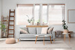 © Pixel-Shot - Interior of light living room with wooden ladder, sofa and plants