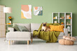 © Pixel-Shot - Cute French bulldog sitting on sofa in living room with autumn decorations