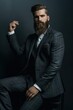 © miss irine - Handsome bearded man in stylish suit poses confidently on black background. Exudes sensuality, style, European charm. Trendy businessman looks pensive, attractive, perfect for fashion, style