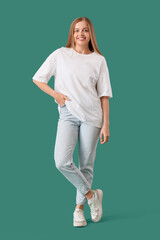 Wall Mural - Young woman in stylish white t-shirt on green background