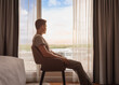 © kieferpix - Thoughtful happy relaxed content man at home looking out his window at the view