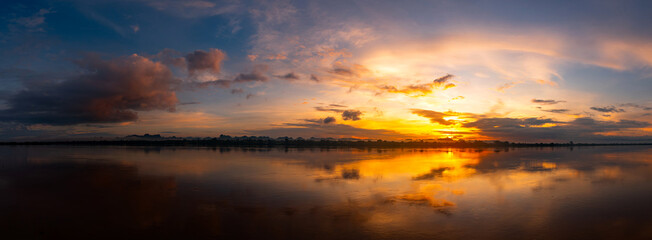 Wall Mural - panorama reflection of vivid sunset sky reflection in water.colorful sunrise with clouds over mekong