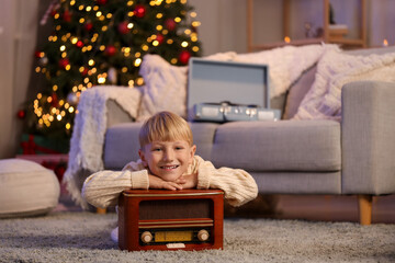 Sticker - Cute little boy with retro radio receiver at home on Christmas eve