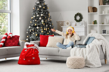 Sticker - Cute little girl in headphones sitting at home on Christmas eve