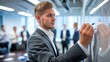 © KwanchanokNPT - Businessman writing on whiteboard during a meeting.