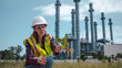 © APchanel - Engineers wear safety gear inspecting or document related to plants environment features large industrial chimneys related energy industrial work and environmental monitor carbon credit concept.