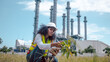 © APchanel - Engineers wear safety gear inspecting or document related to plants environment features large industrial chimneys related energy industrial work and environmental monitor carbon credit concept.