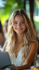 Wall Mural - Young woman smiles as she uses her laptop.