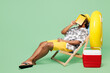 © ViDi Studio - Full body side view young Indian man wear beach shirt hat rest near hotel pool sit in deckchair read book cover face sleep isolated on plain green color background Summer vacation sea sun tan concept