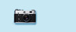 © evgeeenius - A vintage retro camera placed flat on a bright blue background