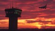 © Thanthara - Air traffic control tower of airport with a departing Boeing 737 in the background at sunset.