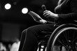 © Premreuthai - Speaker on wheelchair, holding a mic, engaging audience.