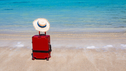 The Red luggage on the beach- summer travel concept