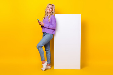 Wall Mural - Full length photo of pretty shiny woman wear violet shirt chatting modern gadget emtpy space isolated yellow color background