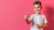 © eartist85 - Smiling young boy giving thumbs up, on a solid color background.