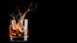 © reddish - Ice cubes splash into a glass of whiskey on a dark background in a dramatic moment