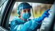 © AlgoCreative - Healthcare worker in protective gear assisting at a drive-through medical site.