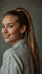 Girl with a ponytail smiling at the camera.