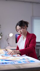 Wall Mural - young asian woman designing a user interface for a mobile application in a modern office environment