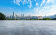© oksa_studio - Empty marble floor overlooking modern city skyline under blue sky