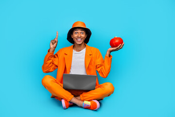 Canvas Print - Photo of amazed fashion stylish guy sit hold pumpkin with netbook point finger up empty space for halloween ads isolated blue color background